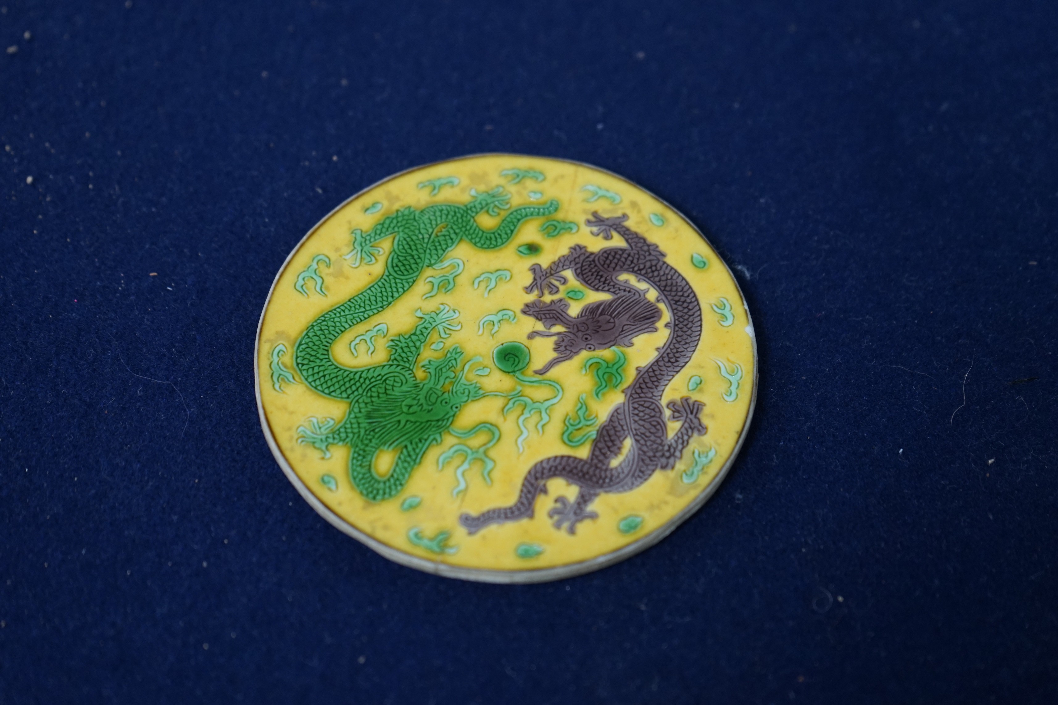 A Chinese sancai porcelain ‘dragon’ roundel, cut from the centre of a dish, Daoguang mark and period, 9cm diameter